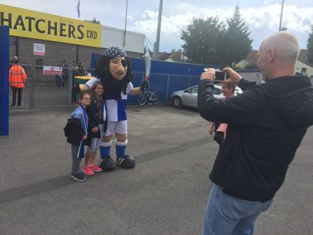 Bristol Rovers' pirate mascot has his photo taken with a fan.