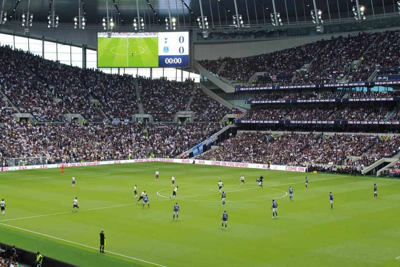 Players on the field in a full Tottenham Hotspur Stadium.