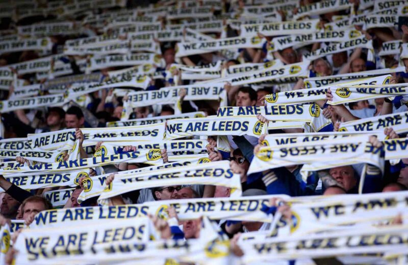 Premier League Leeds fans holding supporter scarves
