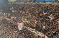 fans waving banners and flags at a football game