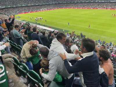 football supporters hugging each other after their team scored a goal.