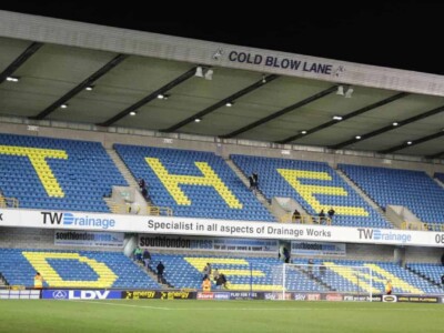 The Cold Blow Lane End at Millwall FC A football stadium with the words The Den written on the seats.