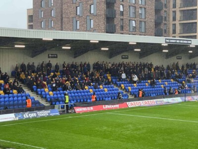 The "away lot" from Burton Albion. fans in the away end at AFC wimbledon