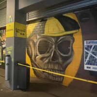 graffiti of a skeleton wearing a black and gold hat