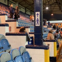 the front few rows of a football stand, with a players tunnel visible.