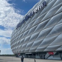 people kicking a football outside the bayern munich stadium
