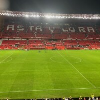 a red football stadium with the words "casta y coraje" written in white on the seats